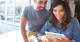 Fashion couple using a tablet with sunbeams and lens flare