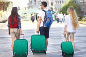 Travelers friends with luggage walking by street in the city. Selective focus